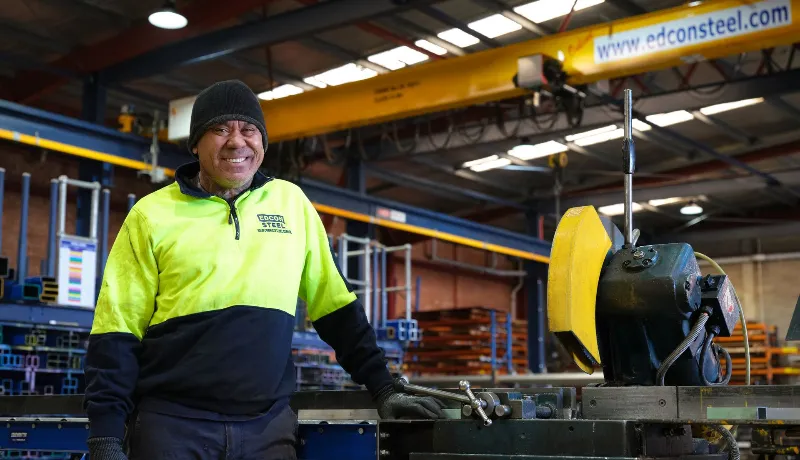 Workers smiling at the camera while working inside the warehouse