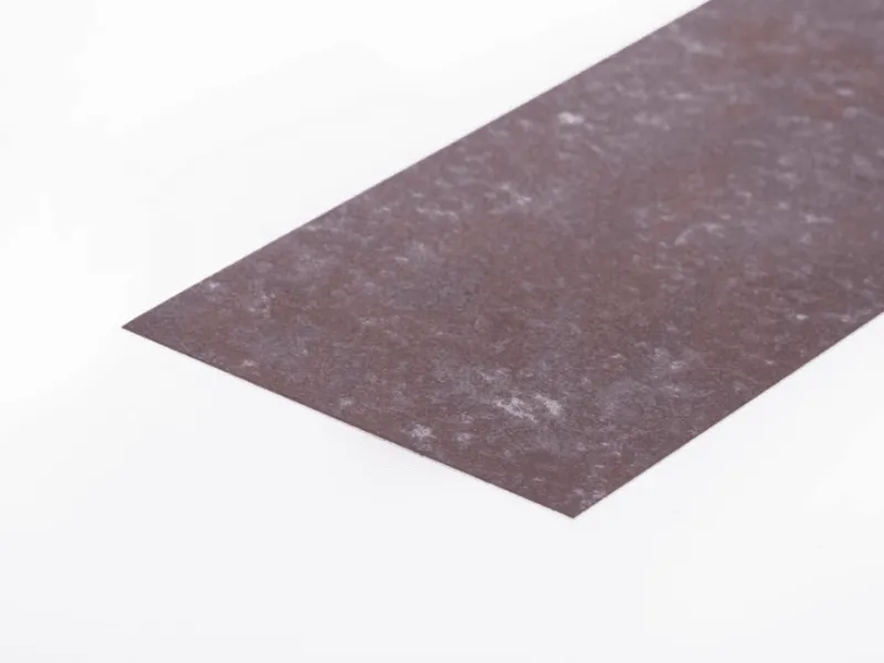 A close-up view of a flat rectangular sheet of Corten weathering steel, showing its characteristic dark brown, mottled surface texture.