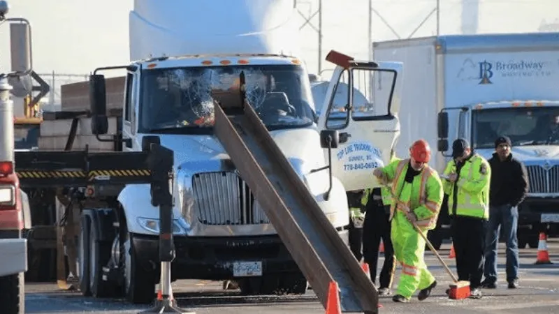 Truck crash scene where a steel beam has penetrated the cabin due to improper load securing