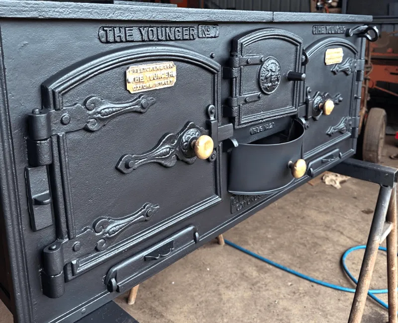 Restored The Younger No.7 cast iron wood stove with polished handles and detailed finish.