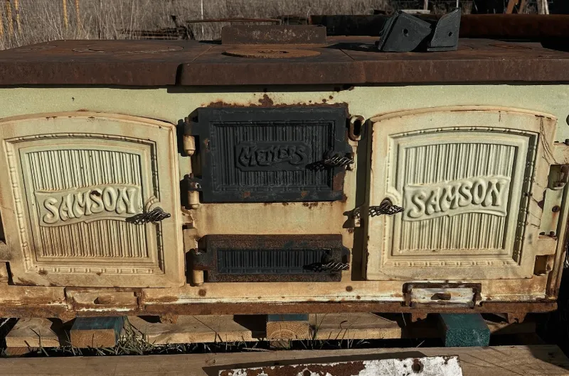Rusty antique Samson wood stove showing wear and ageing before restoration.