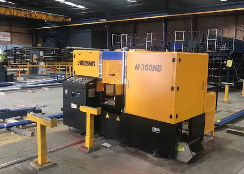 Industrial steel processing machine operating inside a manufacturing warehouse facility.