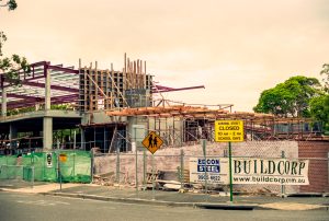 Construction site with wooden scaffolding and steel beams under construction, a 'Cardinal Street Closed' sign visible in the foreground.